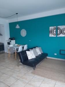 un soggiorno con divano e parete blu di Hermoso departamento en complejo residencial a Tigre