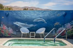 un mural de ballenas y delfines en una pared en Desert Hot Springs Inn, en Desert Hot Springs