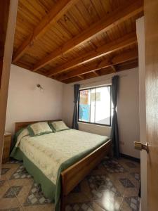 1 dormitorio con cama y ventana en Cabañas Las Palmeras Pichilemu, en Pichilemu