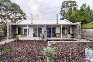 uma casa com uma casa de pedra com um quintal em Freycinet Stone Studio 8 - Sandstone em Coles Bay