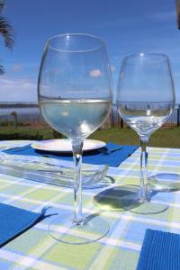 dos vasos de vino blanco sentados en una mesa en Stunning lakefront 4-bedroom, 2.5-bath home en Gorokan