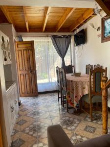 a dining room with a table and a window at Cabañas Las Palmeras Pichilemu in Pichilemu