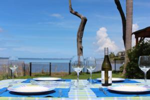 una mesa con copas y una botella de vino en Stunning lakefront 4-bedroom, 2.5-bath home en Gorokan