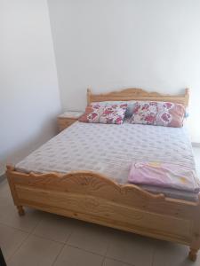a bedroom with a wooden bed with two pillows at Appart bades 