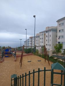 an empty playground with swings in a city at Appart bades 