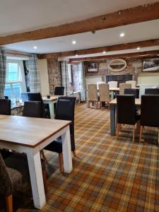 un comedor con mesas y sillas en un edificio en Peak District, The Greyhound Inn, Warslow circa 1750, en Warslow