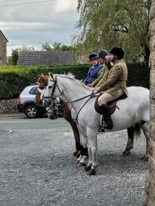 a group of people riding on the back of a white horse at Peak District, The Greyhound Inn, Warslow circa 1750 in Warslow