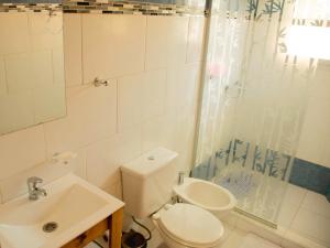 Un baño con inodoro, lavabo y ducha. en Vina, en Villa Elisa 48 fotos más