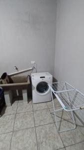 a toilet in a bathroom with a washing machine at Casa del Río in Puerto Iguazú