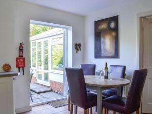 The Dairymans Cottage في يورك: غرفة طعام مع طاولة وكراسي ونافذة