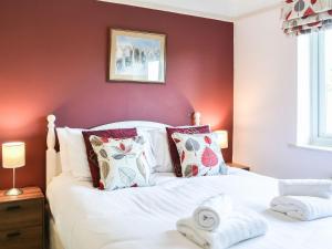 a bedroom with a white bed with red walls at The Dairymans Cottage in York