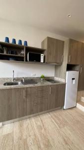 a kitchen with brown cabinets and a white refrigerator at Syrena 401 y 606 in Playa del Carmen