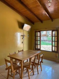 a dining room with a wooden table and chairs at Casa del Río in Puerto Iguazú