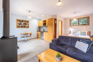 a living room with a blue couch and a kitchen at Freycinet Stone Studio 6 - Mica in Coles Bay