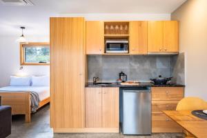 a kitchen with wooden cabinets and a bed in a room at Freycinet Stone Studio 7 - Quartz in Coles Bay