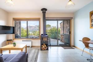 a living room with a wood stove with a view at Freycinet Stone Studio 4 - Granite in Coles Bay