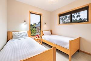 コールズ・ベイにあるFreycinet Stone Studio 5 - Greystoneの窓が2つある部屋にベッドが2つある