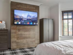 een slaapkamer met een flatscreen-tv aan de muur bij Hampton House in Blackpool