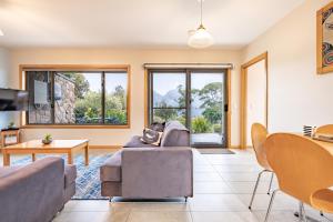 a living room with a couch and a table at Freycinet Stone Studio 5 - Greystone in Coles Bay
