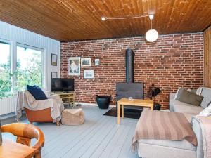 sala de estar con pared de ladrillo y chimenea en Holiday home Struer XXV en Struer
