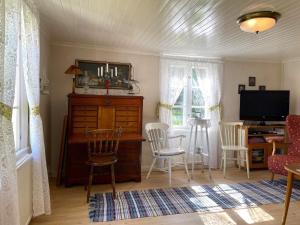 a living room with a table and chairs and a television at Holiday home GRÄSTORP in Grästorp