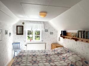 Schlafzimmer mit einem Bett und einem Fenster in der Unterkunft Holiday home GRÄSTORP in Grästorp