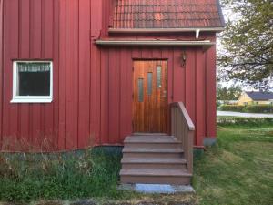 a red building with stairs leading to a door at Holiday home LJUSDAL III in Ljusdal