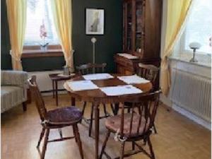 a dining room with a wooden table and chairs at Holiday home LJUSDAL III in Ljusdal