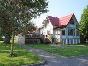 a house with a red roof and a tree at Holiday home RONNEBY IX in Ronneby