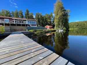 a dock on a lake with a house in the background at Holiday home BRUZAHOLM III in Bruzaholm