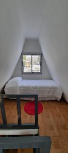 Entre Cardos y Nieves في بوتريريلوس: غرفة نوم بسرير ونافذة في العلية