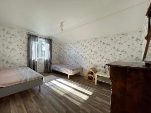 1 dormitorio con 2 camas, escritorio y ventana en Holiday home BRUZAHOLM III, en Bruzaholm