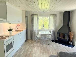 a kitchen with a table and a stove and a window at Holiday home VÄDDÖ VI in Väddö