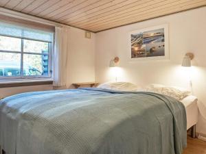a bedroom with a bed and a window at Holiday home Nexø XLI in Neksø