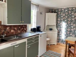 a kitchen with green and white cabinets and a sink at 2 person holiday home in HENÅN in Henån