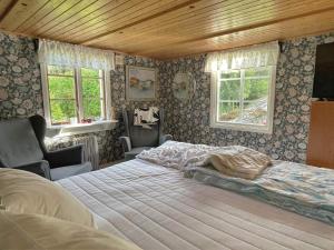 a bedroom with a large bed and two windows at 2 person holiday home in HENÅN in Henån