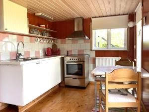 a kitchen with a table and a sink and a stove at Holiday home GAMLEBY VI in Gamleby