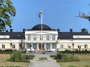 a large white building with a flag in front of it at Holiday home GAMLEBY VI in Gamleby