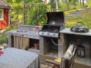 kuchnia na świeżym powietrzu ze sprzętem do grillowania i stołem w obiekcie Holiday home öRSJö II w mieście Örsjö