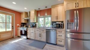 a kitchen with wooden cabinets and stainless steel appliances at A newly built Tiny House in the center of Historic Kennett Square in Kennett Square