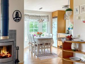 a kitchen and dining room with a table and a fireplace at Holiday home HJO III in Hjo