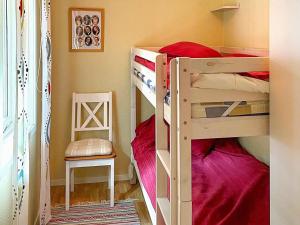 een slaapkamer met 2 stapelbedden en een stoel bij Holiday home HJO III in Hjo