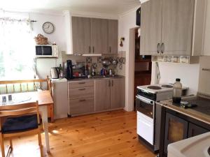 uma cozinha com uma mesa e um fogão forno superior em Holiday home RAMSJÖ II em Ramsjö