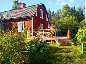 uma casa vermelha com um deque e um quintal em Holiday home RAMSJÖ II em Ramsjö
