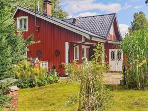 une maison rouge avec un jardin en face dans l'établissement Holiday home Annerstad, à Skärseryd