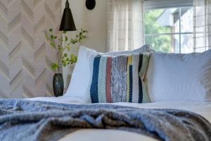 a bed with pillows and a blanket on it at A newly built Tiny House in the center of Historic Kennett Square in Kennett Square