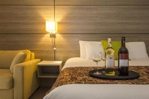 a hotel room with a bed with two bottles and wine glasses at Living Stone Golf Resort in Collingwood