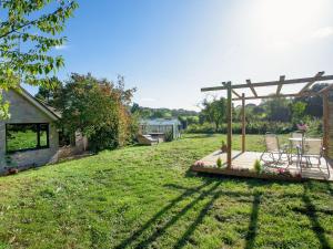 een achtertuin met een houten terras met een tafel en stoelen bij Purlbridge Bungalow in Southleigh
