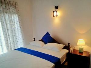um quarto com uma cama grande com lençóis azuis e brancos em The Tourist Balcony em Negombo