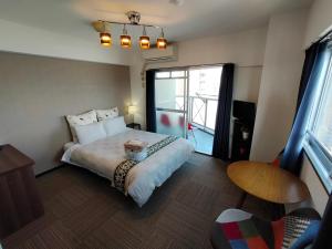 a bedroom with a large bed and a window at Coco Fukuoka Chiyo in Fukuoka